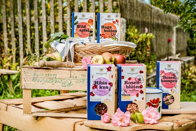 Photo of several packages of fruit tea. In the background you can see a fence. | © SONNENTOR