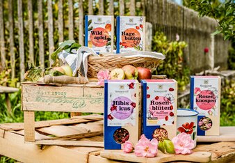 Photo of several packages of fruit tea. In the background you can see a fence. | © SONNENTOR