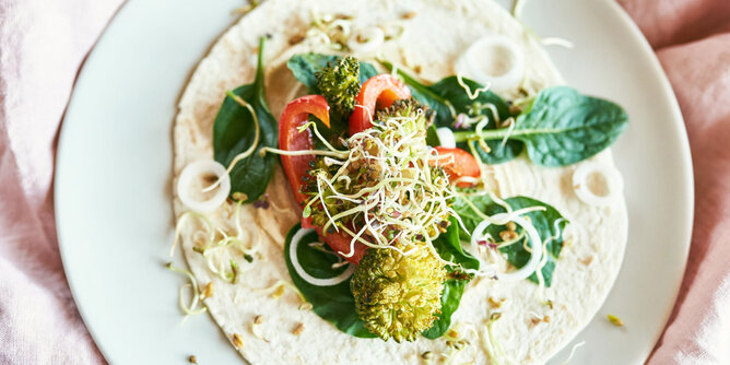 Nudelholz Sprossen Rezepte | © SONNENTOR Auf dem Foto sieht man einen Wrap mit Gemüse. Darauf sind Sprossen verteilt. | © SONNENTOR